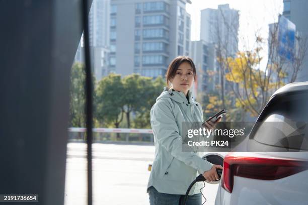 asian women using smart phone in at the charging station. - battery life stock pictures, royalty-free photos & images