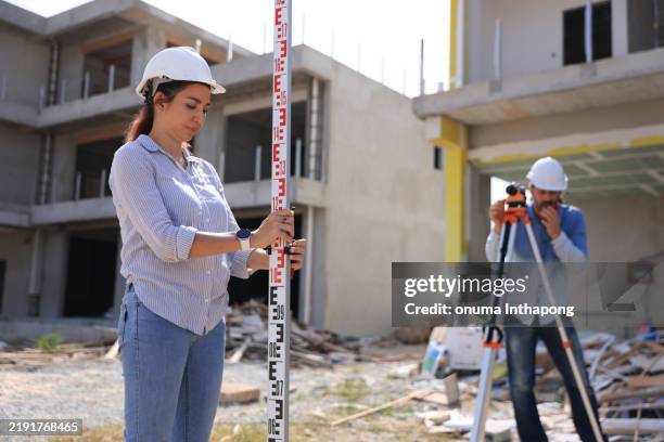 two survey engineers team working with surveying level cameras and transition level at the home office construction site - tacheometer stock pictures, royalty-free photos & images
