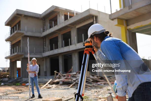 two survey engineers team working with surveying level cameras and transition level at the home office construction site - tacheometer stock pictures, royalty-free photos & images