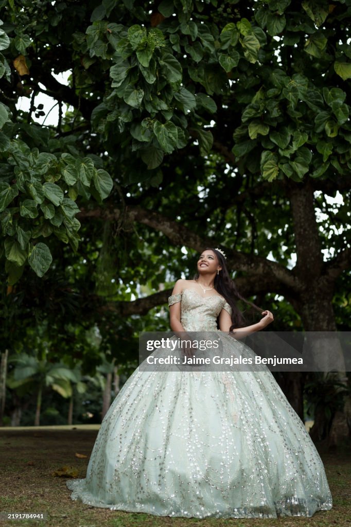 15 years teenager girl wearing elegant dress and tiara posing in garden