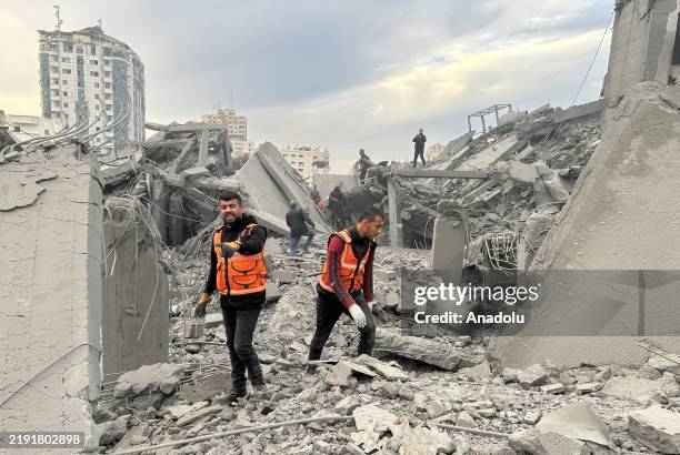 Civil defense teams and citizens launch a search and rescue operation in the rubble after the Israeli army attacked the building where the Al-Ashi...