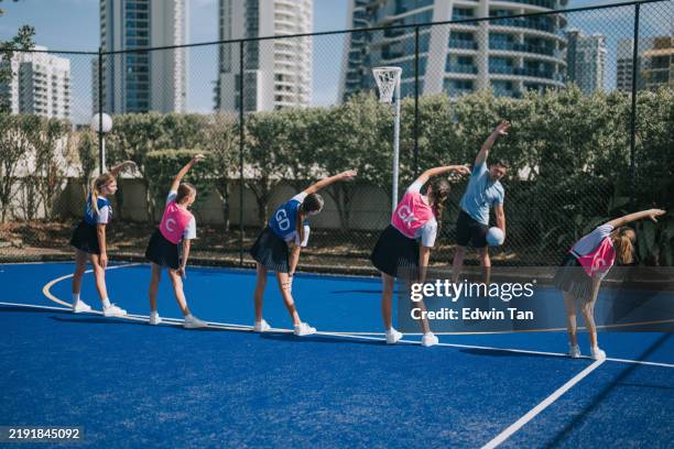 morning warm up exercise australian teenage girl netball players with coach at netball court - warm up exercise stock pictures, royalty-free photos & images