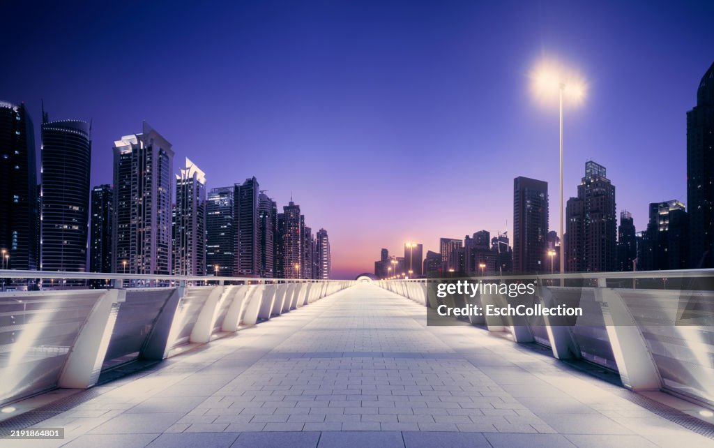 Pedestrian overpass in modern city at sunset