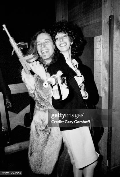 Portrait of American Rock musician Ted Nugent and Epic Records publicist Susan Blond, both holding toy machine guns, at SIR Studios, New York, New...