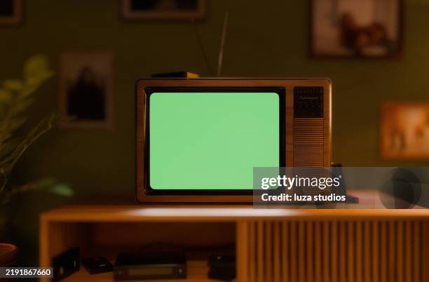 tv rétro avec écran vert dans un intérieur de salon vintage avec des murs verts et des meubles rétro la nuit - tube cathodique photos et images de collection