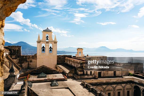 historischer glockenturm mit blick auf die küste in neapel, italien an einem sonnigen tag - altstadt stock-fotos und bilder