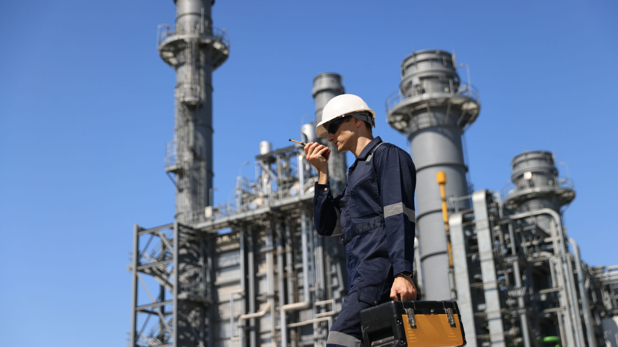 Maintenance Engineer using a walkie-talkie and hold toolbox working at a thermal power plant Maintenance Engineer using a walkie-talkie and hold toolbox working at a thermal power plant