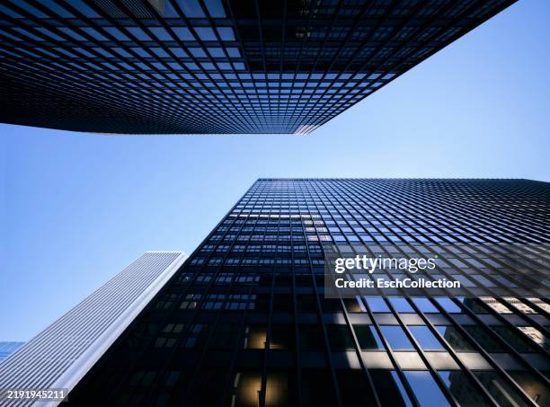 looking up at modern office buildings on a clear, sunny day - architectonisch element stockfoto's en -beelden