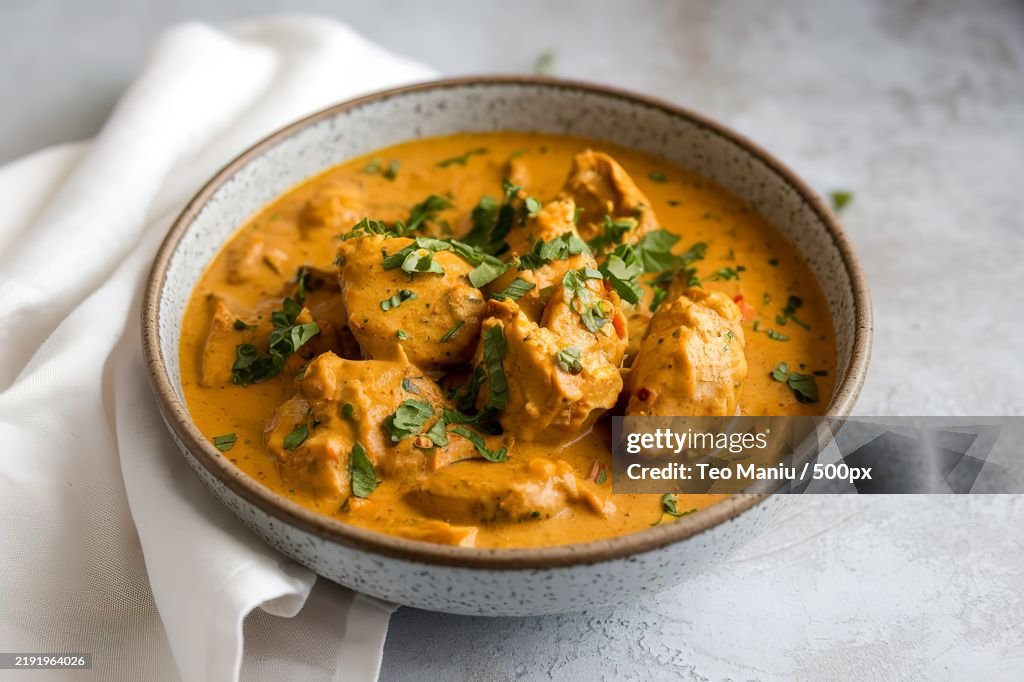 A bowl of richly colored chicken curry