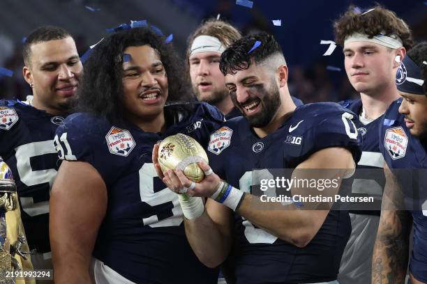 Dominic DeLuca of the Penn State Nittany Lions holds the Fiesta Bowl Trophy following the 2024 Vrbo Fiesta Bowl against the Boise State Broncos at...