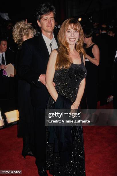 American actress Cassandra Peterson, wearing a sparkling black evening gown, and her husband, Mark Pierson, who wears a black suit over a white shirt...
