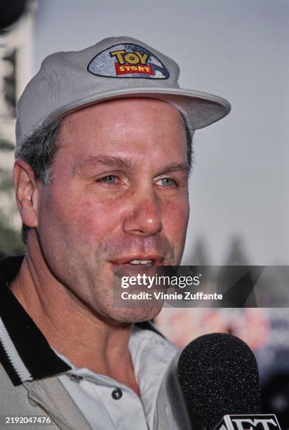 American media executive Michael Eisner, wearing a 'Toy Story' baseball cap, as he is interviewed at the Hollywood premiere of 'Toy Story' at the El...