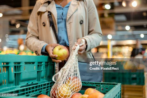 sustainable shopping: black woman with eco-friendly bags and fresh produce - herbruikbare tas stockfoto's en -beelden