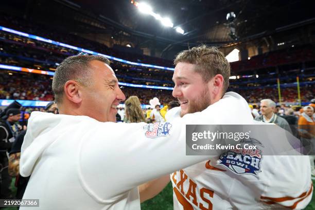 Head coach Steve Sarkisian of the Texas Longhorns hugs Quinn Ewers after defeating the Arizona State Sun Devils 39-31 during the second overtime in...