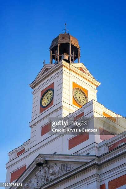 tower of the clock on casa de correos at puerta del sol square during sunset - madrid, spain - klokkentoren-met-wijzerplaat stockfoto's en -beelden