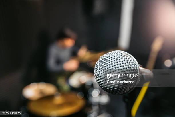 microphone on a mic stand during a band rehearsal in a studio - músico de rock imagens e fotografias de stock