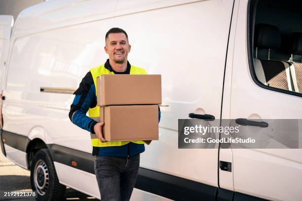 delivery man carrying packages - entregador imagens e fotografias de stock