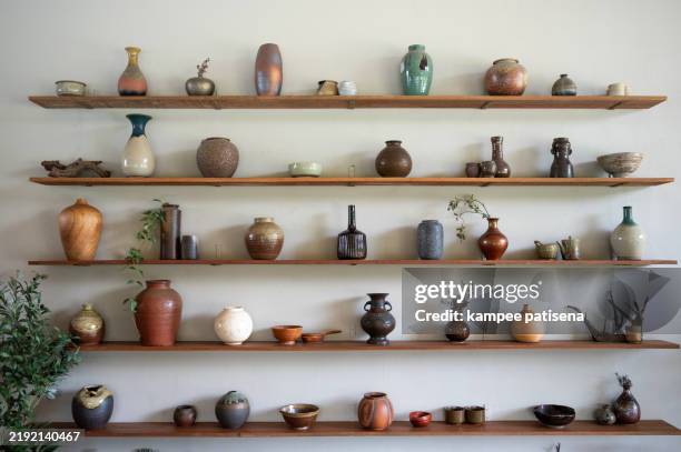 collection of ceramic vases on wooden shelves - antique pottery vases stock pictures, royalty-free photos & images