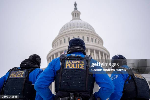 The Dome of the U.S. Capitol Building is visible as U.S. Capitol Police officers stand guard in a winter storm in the nation's capital on January 6,...