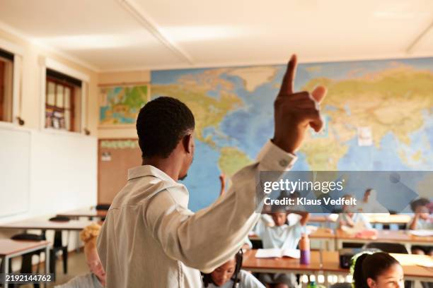 teacher pointing and teaching group of students - tutor stock pictures, royalty-free photos & images