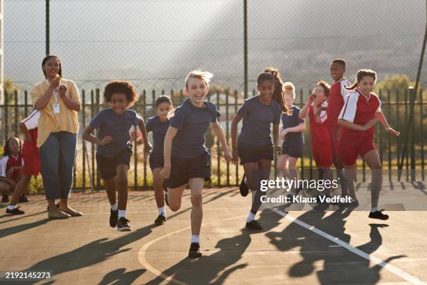 schoolgirls running race on track field - physical education stock pictures, royalty-free photos & images