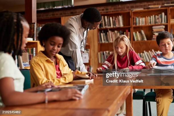 librarian assisting elementary student - librarian help stock pictures, royalty-free photos & images