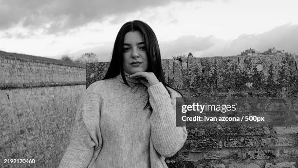 portrait of young woman standing against wall - azcona stock pictures, royalty-free photos & images
