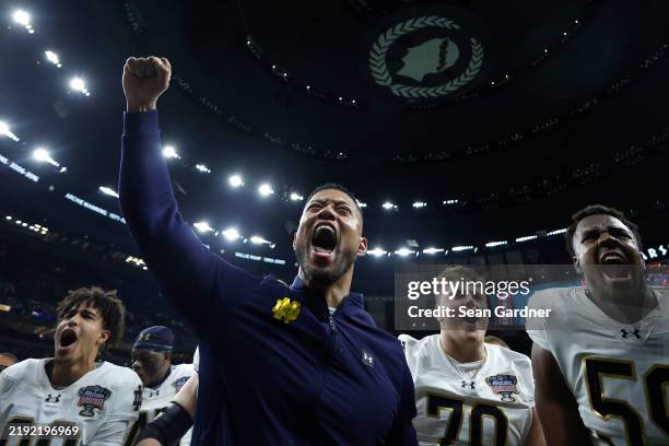 Head coach Marcus Freeman of the Notre Dame Fighting Irish celebrates with his team after a 23-10 victory against the Georgia Bulldogs in the 91st...
