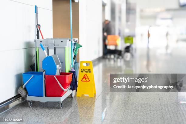 airport cleaning supplies, a yellow mop bucket, and a cleaning tools cart waiting for cleaning - caretaker stock pictures, royalty-free photos & images
