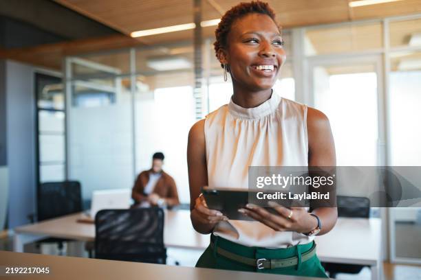 confident professional with tablet in modern office - crèmekleurige broek stockfoto's en -beelden