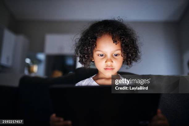 intrigued child with glowing tablet - onschuld stockfoto's en -beelden