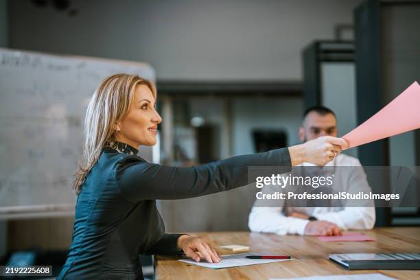 professional team engaged in a document review during an office meeting - delegating stock pictures, royalty-free photos & images