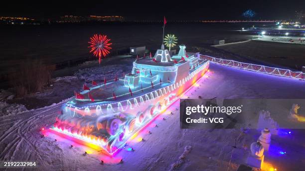 Snow sculpture featuring Chinese Navy's Type 055 destroyer is illuminated on the bank of Songhua River on January 2, 2025 in Harbin, Heilongjiang...