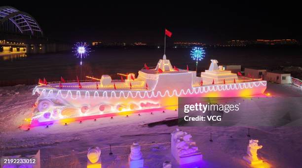 Snow sculpture featuring Chinese Navy's Type 055 destroyer is illuminated on the bank of Songhua River on January 2, 2025 in Harbin, Heilongjiang...