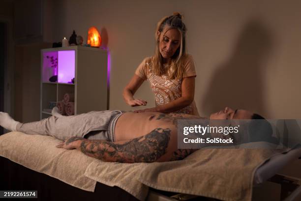 reiki and mindfulness practices - male masseur stock pictures, royalty-free photos & images