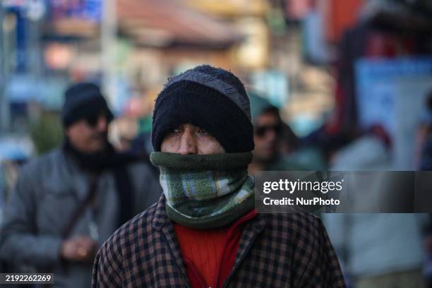 Man covers his face as he walks along a road in Srinagar, Jammu and Kashmir, on December 7, 2025. India reports seven cases of the Human...