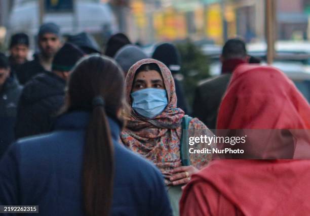 Woman wearing a protective face mask walks along a road in Srinagar, Jammu and Kashmir, on January 7, 2025. India reports seven cases of the Human...