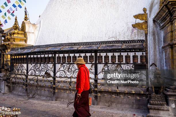 Devotee turns a prayer wheel around the Swayambhunath Stupa in Kathmandu, Nepal, on January 7, 2025.
