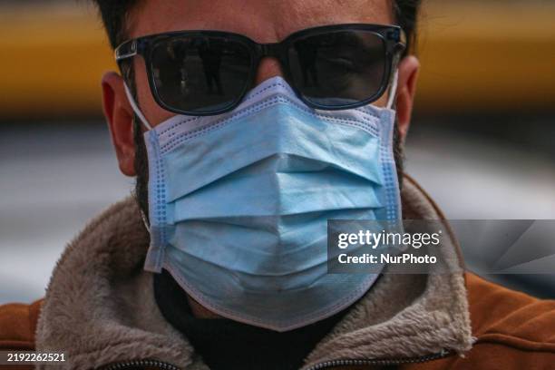 Man wearing a protective face mask walks along a road in Srinagar, Jammu and Kashmir, on December 7, 2025. India reports seven cases of the Human...