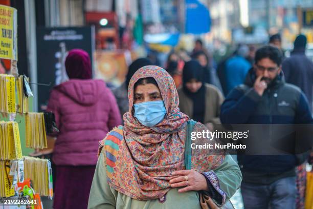 Woman wearing a protective face mask walks along a road in Srinagar, Jammu and Kashmir, on January 7, 2025. India reports seven cases of the Human...