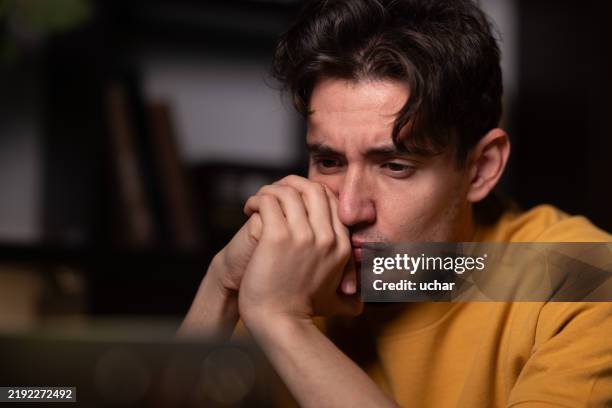 young man feeling stressed and anxious while working at home - information overload stock pictures, royalty-free photos & images