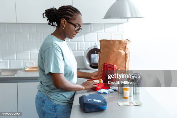 mujer prepara un botiquín de primeros auxilios en una cocina moderna y organizada - preparación de alimentos fotografías e imágenes de stock