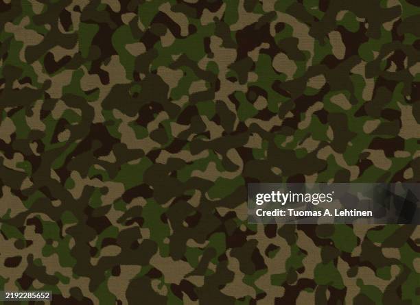 close-up of brown and green camouflage pattern on a textile fabric. - camouflage stock pictures, royalty-free photos & images