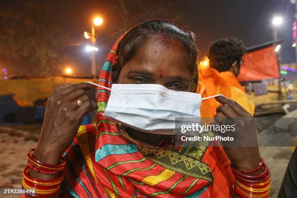 Woman with her children waits for a rapid antigen test amid Human Metapneumovirus at the emergency department of a hospital in Kolkata, India, on...