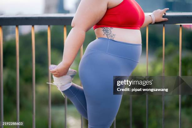 plus size woman doing outdoor exercise in a city park - side bend stock pictures, royalty-free photos & images