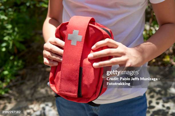 teenager boy holding a first aid kit for emergency preparedness - wilderness first aid stock pictures, royalty-free photos & images