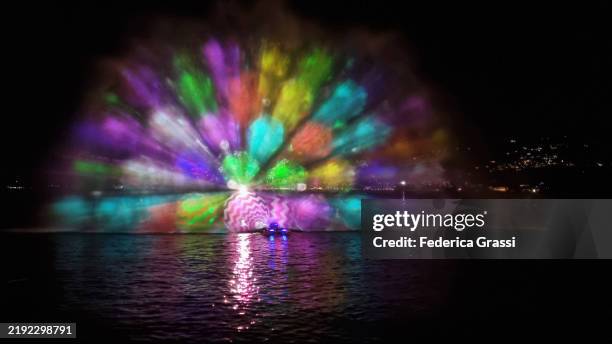 christmas-themed laser light projection on lake maggiore, verbania pallanza, northern italy. part of the unesco biosphere reserve ticino valgrande verbano. - laser light show stock pictures, royalty-free photos & images