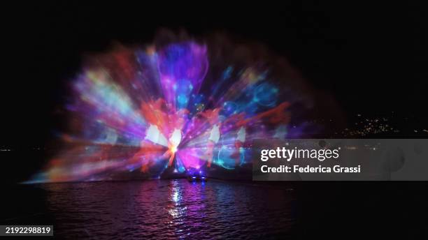 christmas-themed laser light projection on lake maggiore, verbania pallanza, northern italy. part of the unesco biosphere reserve ticino valgrande verbano. - spettacolo con luci laser foto e immagini stock
