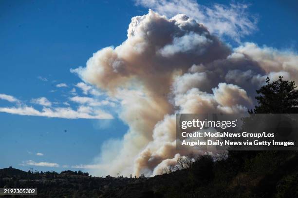 The rising Pacific Palisades fire plume is seen through the Sepulveda Pass in Brentwood, CA during high winds in Pacific Palisades in Los Angeles,...