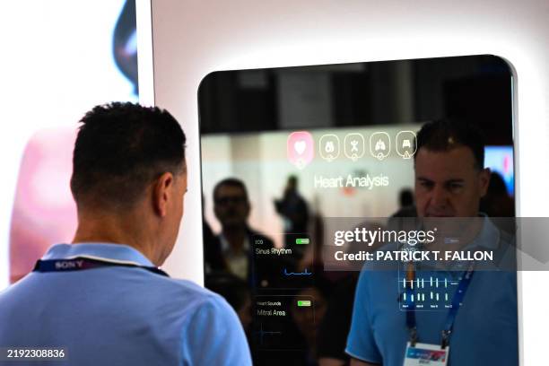 An attendee views blood pressure data in a a mirror during a demonstration of the Withings OMNIA concept health screening scanner and smart scale at...